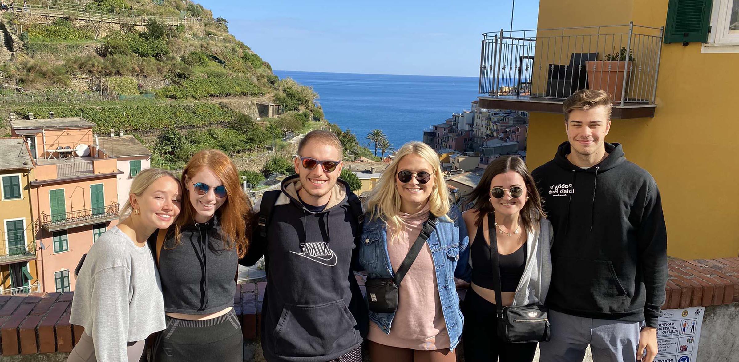 Group of study abroad students with a seaside background